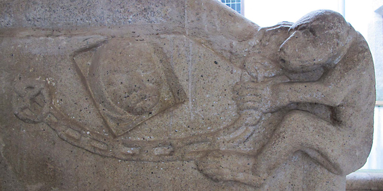Escultura en piedra labrada sobre la escalera interior de la Casa del Mono en Cáceres